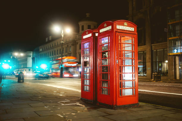 istock Red pay phone booth in London at night 864342408