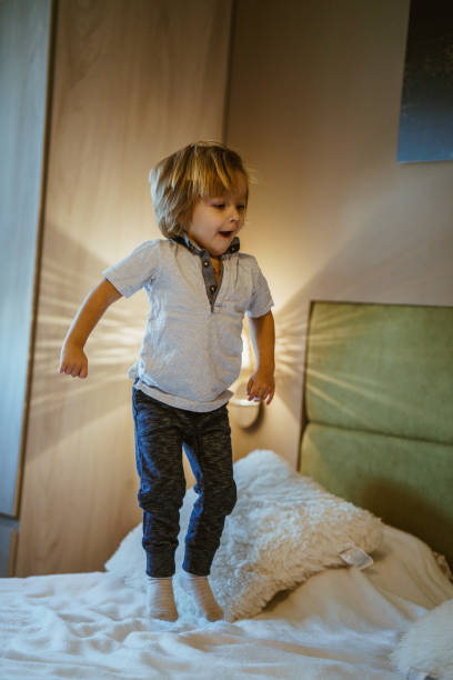 istock Cute boy jumping on the bed 864342680