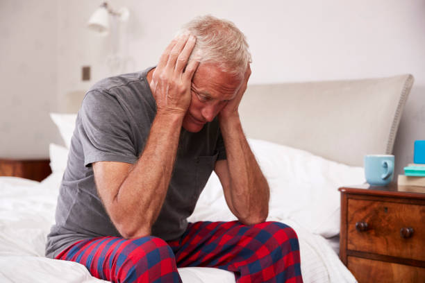istock Senior Man Sitting On Bed At Home Suffering From Depression 864343124