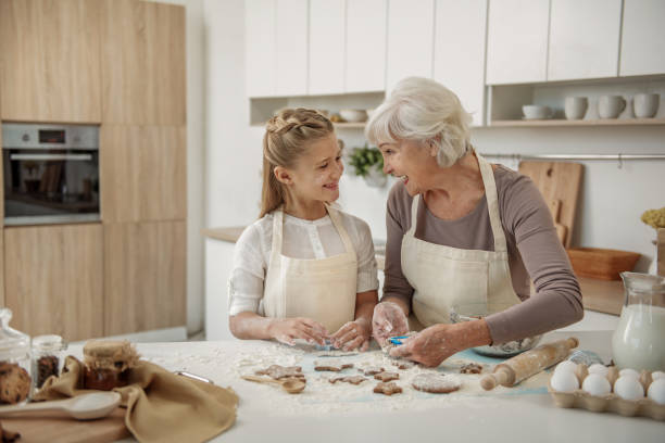 istock Joyful grandmother teaching kid how to make cookies 864351498