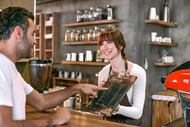 istock Staff Serving Customer In Busy Coffee Shop 864352262