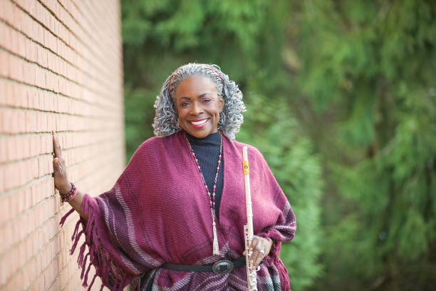 Beautiful Flutist A beautiful woman outdoors in the fall holding her flute. black shawl wrap stock pictures, royalty-free photos & images