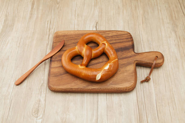 istock pretzel German bread on wood plate knife isolated on table 864363592