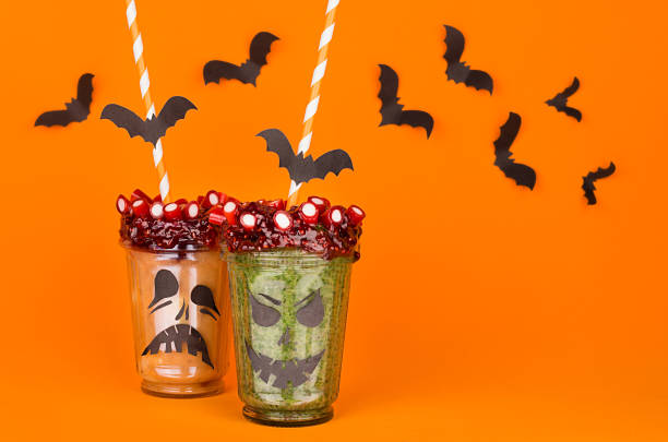 istock Halloween food. Fun monsters smoothie on orange background. 864366688