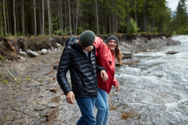 istock Young couple having fun on a riverside. Man picking up his girlfriend 864371304