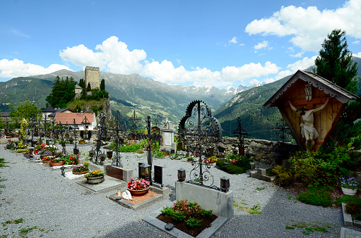 Austria, cemetery in mountain village Ladis with view to Kaunertal valley and Tyrolean Alps