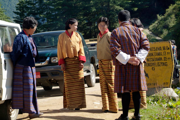 Drukyeldzong, Bhutan - September 20th 2007: unidentified inhabitants in their traditonal dress (Kira and Gho) waiting for transport to a ceremony in Paro village