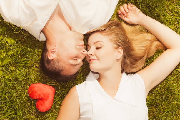 istock Man and woman lying on grass having date 864374954
