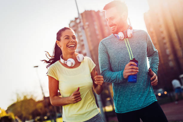 istock Young attractive couple running outside on sunny day 864381728