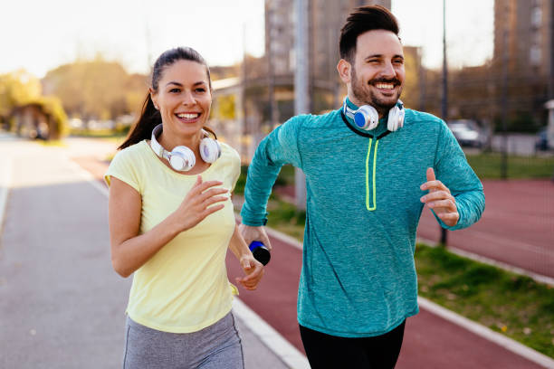 istock Young attractive couple running outside on sunny day 864383790