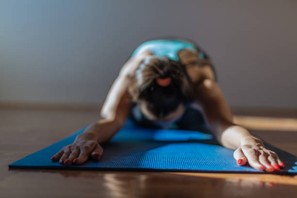 istock Yoga practicing in her living room 864384744