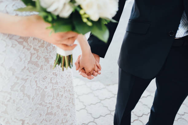 istock Bride and Groom holding hands 864385442