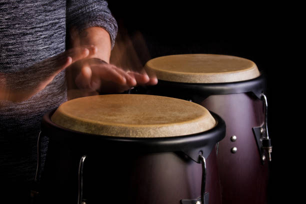 Hands of Cuban street band drummer hitting drums.