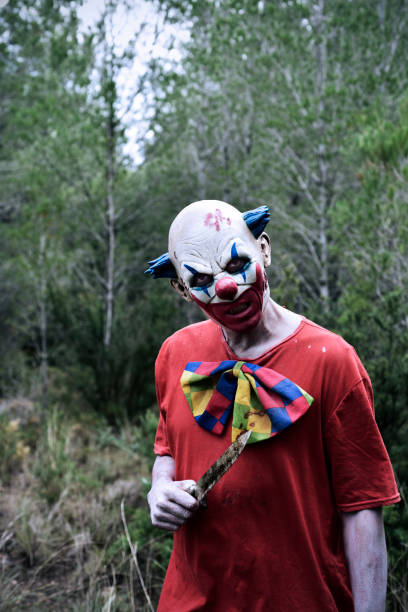 istock scary evil clown with a knife in the woods 864398594
