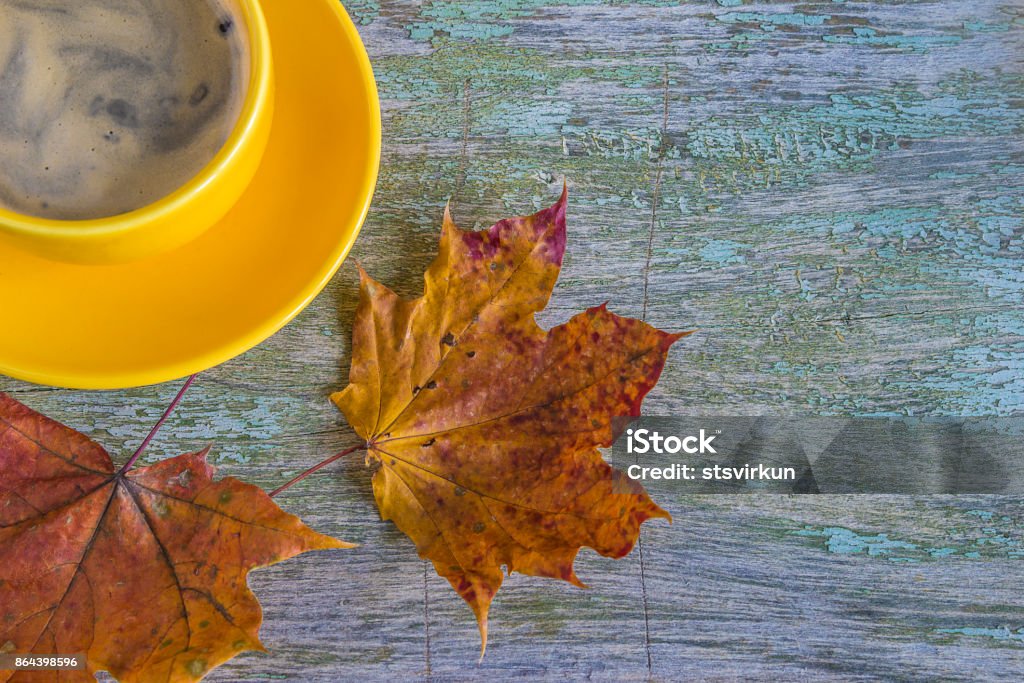 autumne concept yellow cup of coffee and dry maple leaves on rustic background with copy space Autumn Stock Photo
