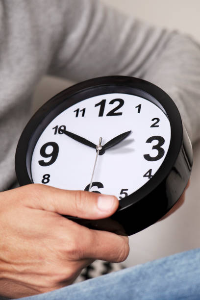 istock man adjusting the time of a clock 864398806