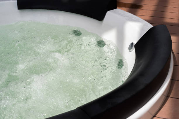 istock Light and shadow of white whirlpool bathtub with water bubbles 864404212