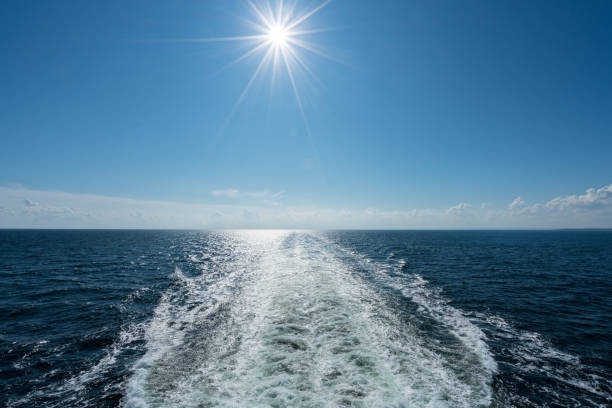 soleil qui brille sur le sillage du navire de croisière en mer - passenger ship flash photos et images de collection