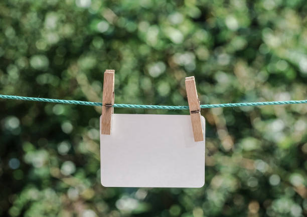 istock empty white paper hanged with clothes pegs on rope at garden 864407356