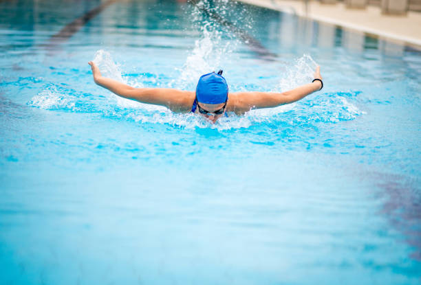 istock Gritty woman swimming butterfly stroke 864408606