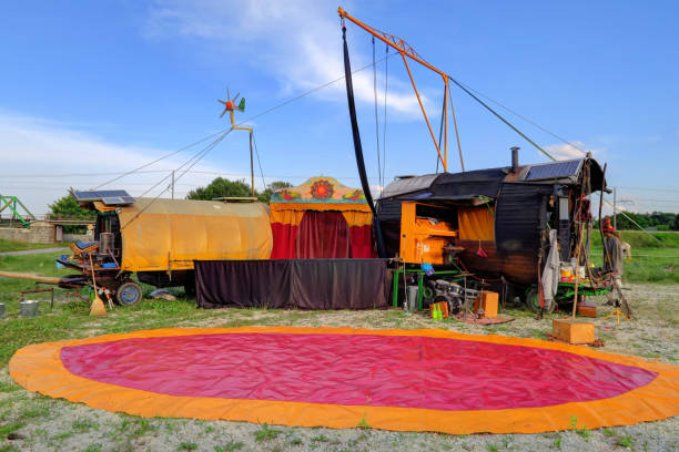Goiania, Goias, Brazil – June 25, 2025: Top of a circus structure, with red and white striped tents and strings of lights lit up, at dusk, with a sky in the background with some clouds.