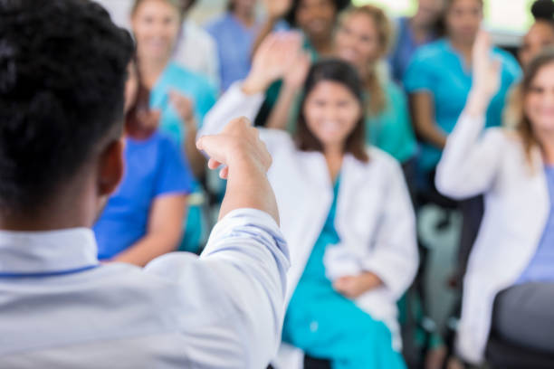 istock Healthcare conference speaker calls on someone to ask question 864411132