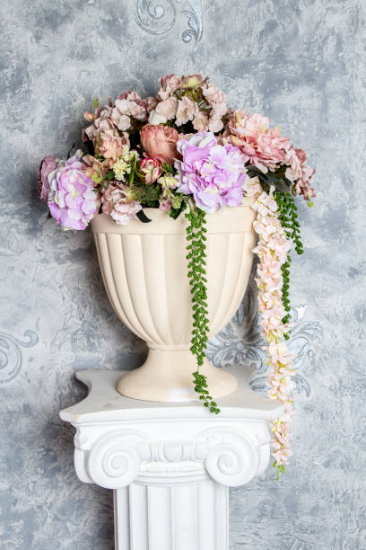 istock Artificial flowers in vase on the greek column 864411622