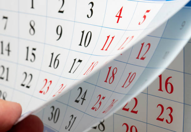 istock Fingers hold the calendar sheet 864412470