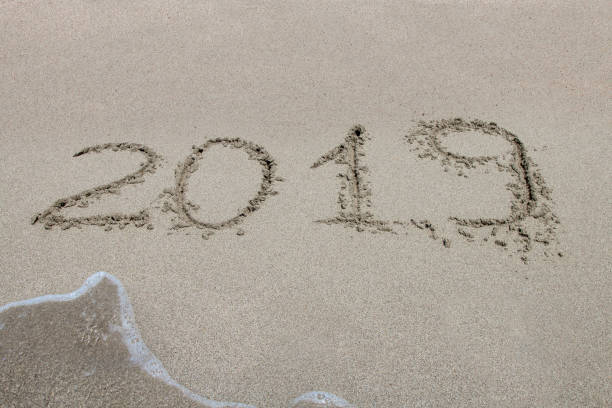 istock 2019 written on the sand of a beach, closeup 864418264
