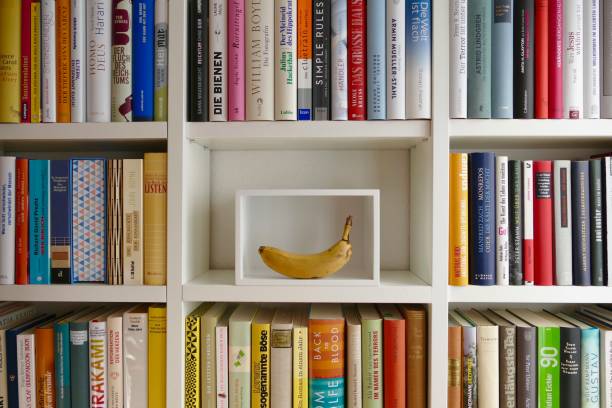 organizing the ibrary: white box presenting a banana - book book spine in a row library imagens e fotografias de stock