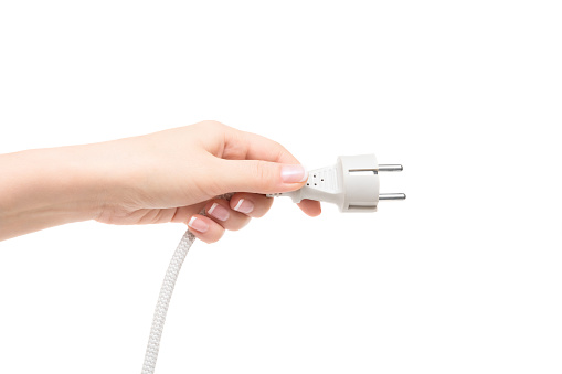 Female hand holds electric cable on a white background.