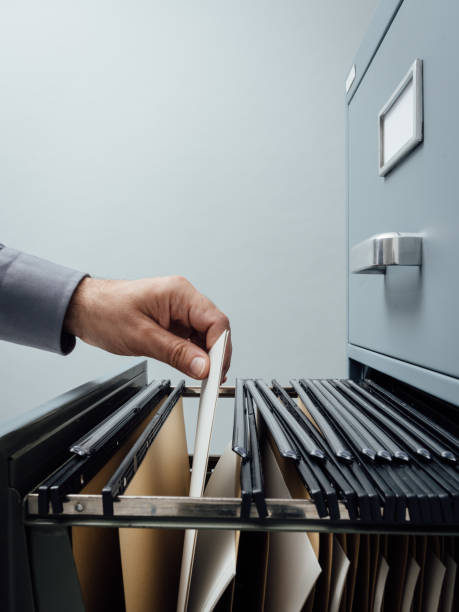 Office clerk searching for files Office clerk searching for files into a filing cabinet drawer close up, business administration and data storage concept filing cabinet photos stock pictures, royalty-free photos & images