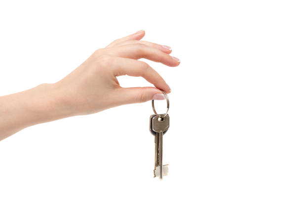 Isolated female hand holds keys on white background.