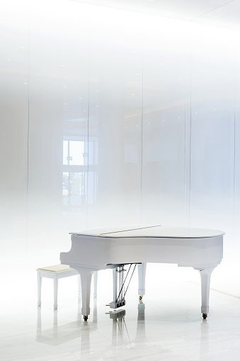 Grand white piano in white interior, Greece.