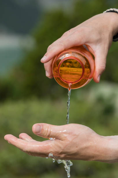istock Hiker pours water from a water bottle on his hands 864437750