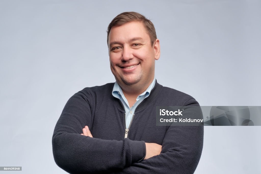 Half body portrait of confident middle aged man with folded arms looking at camera Half body portrait of confident caucasian middle aged man with folded arms looking at camera Men Stock Photo
