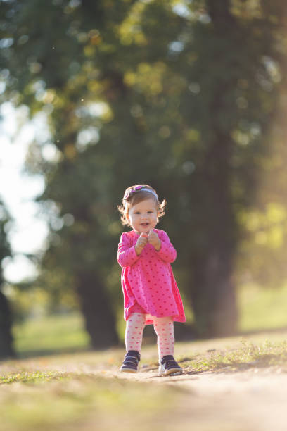 istock Baby girl outdoors in nature taking her first steps 864445478