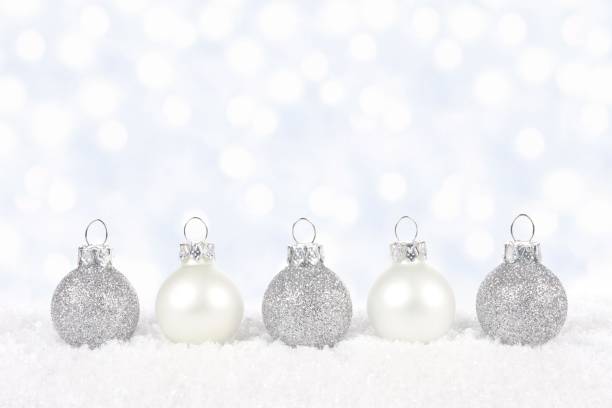 istock White and silver Christmas ornaments in snow 864447918