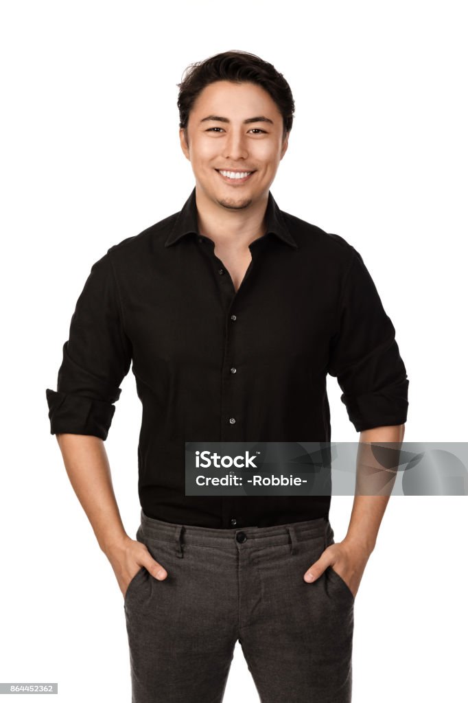Attractive man portrait Attractive man in a black shirt and grey pants, standing with a big smile against a white background, Men Stock Photo