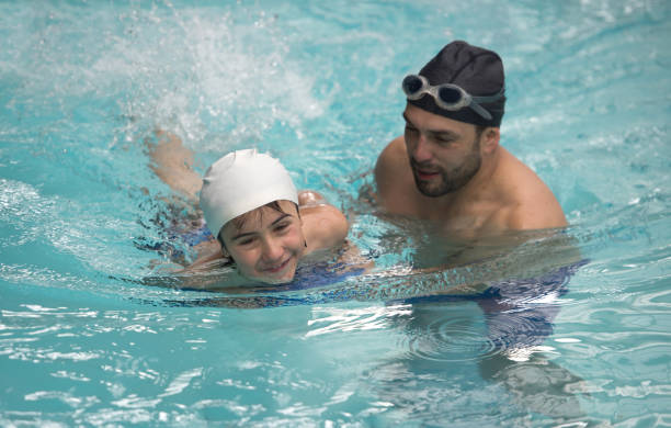 istock Boy taking swimming lessons with a teacher 864453704