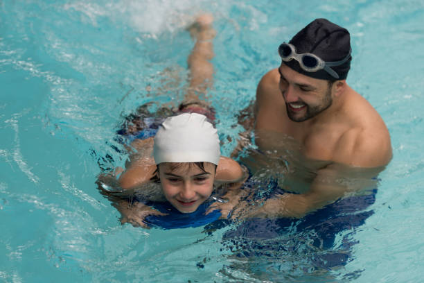 istock Swimming instructor teaching a boy in the pool 864453744