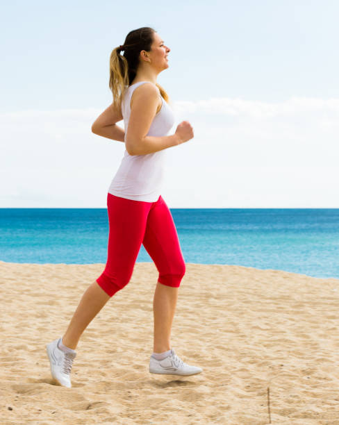 istock Woman running on beach 864458340