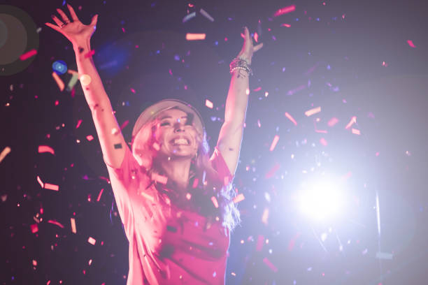 istock Happy woman dancing under confetti at a party 864459306