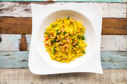 Fried rice with cashew nut and pea on the wooden table