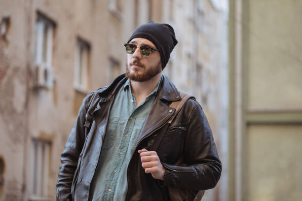 One man, hipster, standng outdoors, casual chloting.