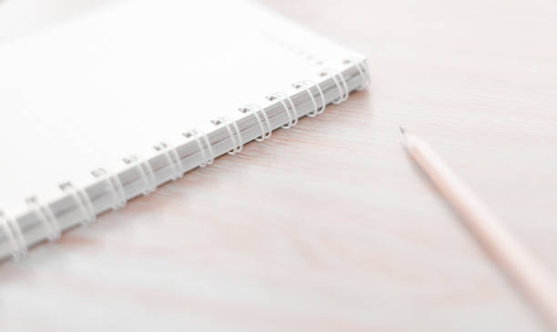 istock Blur pencil and notebook diary concept in white tone. 864463698