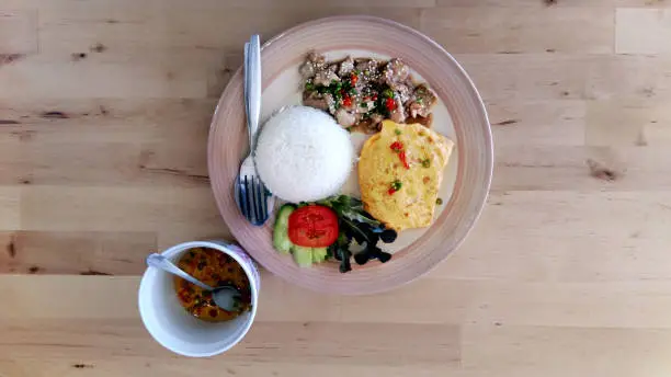 Photo of meats fried ,omelette, and rice of Asia food  on wood table in restaurant  of meals Asia food