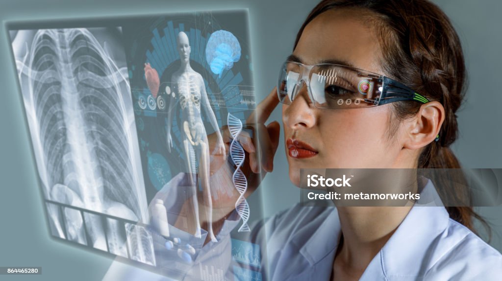 Young female doctor looking at hologram screen. Electronic medical record. Smart glasses. Medical technology concept. Healthcare And Medicine Stock Photo