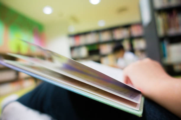 istock Close-up of Students Reading Books in Library 864466220