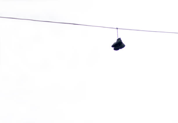Cowboy boots hanging from a power line on a rural backroad.